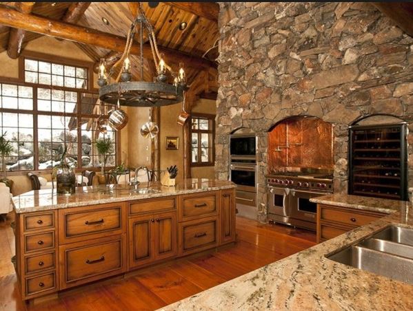 Cocina rural de lujo con horno. Tarima y pared de piedra natural. Arcolinea: Quiénes somos. Reforma general o integral de una cocina rural decorada en madera y piedra con horno, de lujo y muy grande
